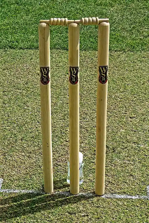 Cricket pitch with wicket stumps and bails