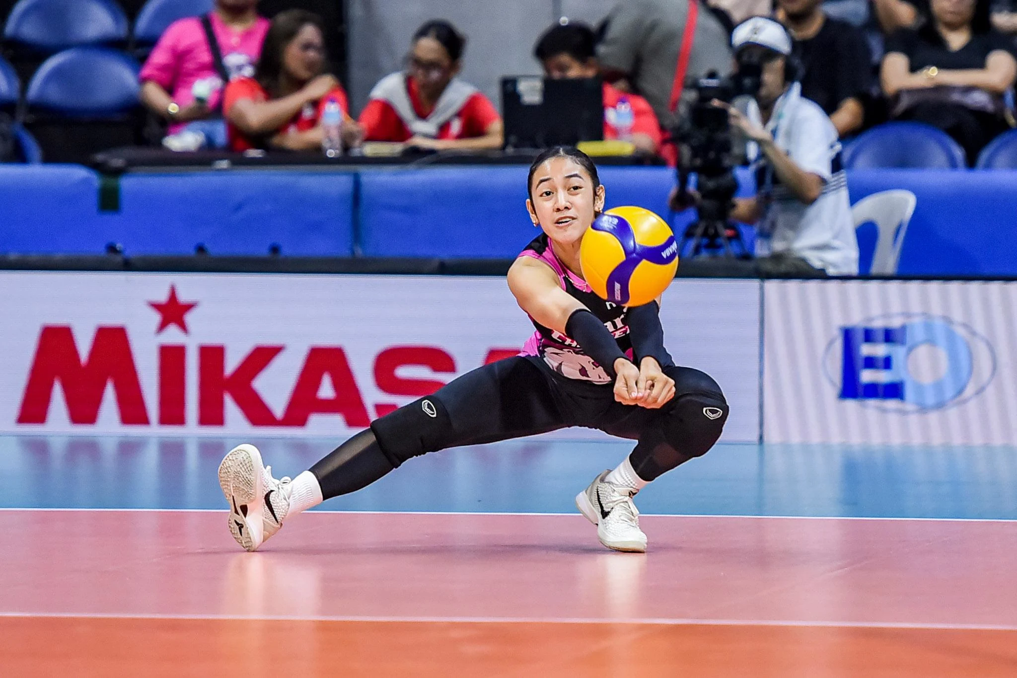 Volleyball attacker spiking the ball against blockers at the net